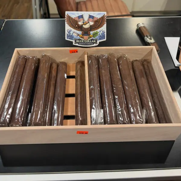 A cedar box of “The Foreman” cigars by Blue Collar Tobacco with the eagle logo standee